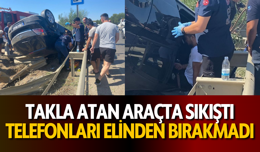 Takla atan araçta sıkıştı, telefonları elinden bırakmadı